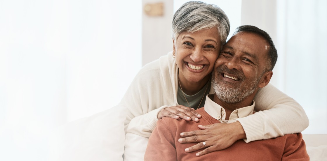 A middle-aged couple smile at the camera